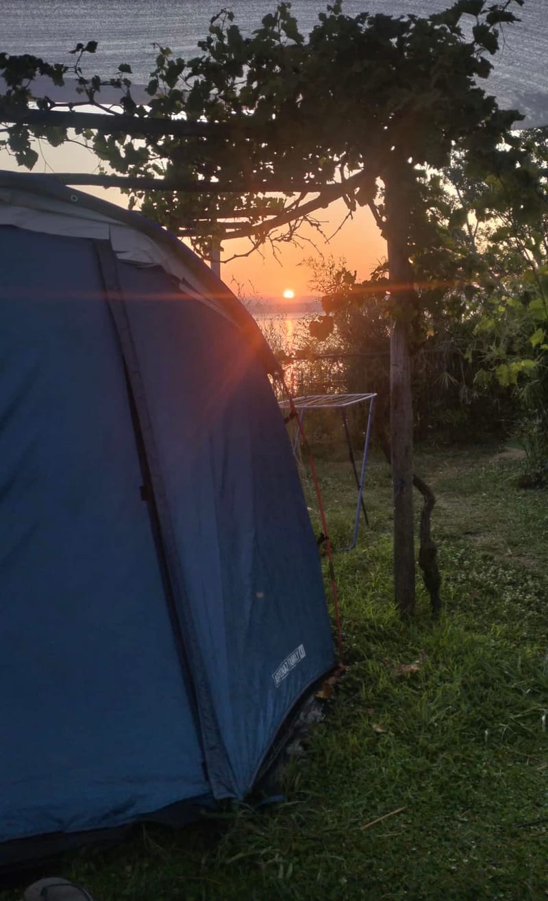 Kempingový stan při západu slunce s výhledem na jezero, varianta s přenocováním